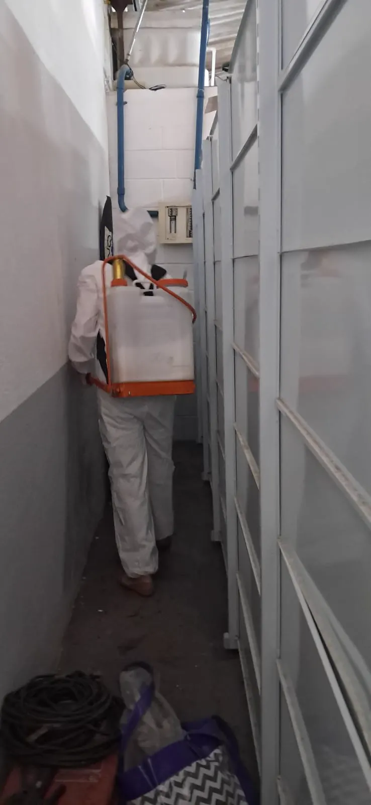 Técnico da PJO com pulverizador em aplicação em corredor interno